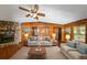 Virtual staging of the living room with sofas, tables, lamps, art, rug, wood walls, and stone fireplace at 2017 S Deshon Rd, Lithonia, GA 30058