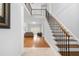 Bright foyer featuring hardwood floors, staircase with iron railings, and an open view to the living area at 3280 Stillhouse Se Ln # 410, Atlanta, GA 30339