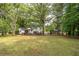 Expansive backyard featuring a spacious wooden deck, lush lawn, and mature trees offering both sun and shade at 4510 Virginia Nw Ave, Kennesaw, GA 30144