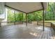Enjoy outdoor living on this large, covered wooden deck surrounded by lush greenery and mature trees at 4510 Virginia Nw Ave, Kennesaw, GA 30144
