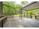 Spacious wooden deck with railings and a covered area overlooks the large grassy lawn and mature trees at 4510 Virginia Nw Ave, Kennesaw, GA 30144