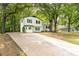 Classic two-story home with a well-manicured lawn, a light blue door, and a long driveway leading up to the house at 4510 Virginia Nw Ave, Kennesaw, GA 30144