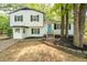 Inviting two-story home featuring white siding, black shutters, a bright blue front door, and landscaped garden beds at 4510 Virginia Nw Ave, Kennesaw, GA 30144