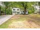 Well-maintained two-story home featuring a bright blue front door, charming bay window, and mature trees at 4510 Virginia Nw Ave, Kennesaw, GA 30144