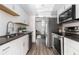Galley kitchen featuring stainless steel appliances, white cabinets, and granite countertops at 26 Ivy Ne Pkwy, Atlanta, GA 30342
