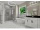 Beautiful bathroom with a soaking tub, glass-enclosed shower, white cabinets, and elegant tile work at 301 Eminence Peak, Rydal, GA 30171