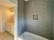 A modern bathroom features unique hexagonal tiles, a bathtub, and a vanity with sconce lighting at 301 Eminence Peak, Rydal, GA 30171