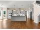 A bright kitchen features stainless appliances, white cabinets, an island, and hardwood floors at 301 Eminence Peak, Rydal, GA 30171