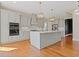This bright, white kitchen features stainless steel appliances, an island, and hardwood floors at 301 Eminence Peak, Rydal, GA 30171
