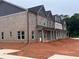 New construction townhome with brick facade, multiple windows, covered entryway, and unfinished front yard at 3230 Cyrus Creek Dr, Kennesaw, GA 30152