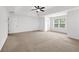 Spacious primary bedroom featuring carpet, tray ceiling, and a ceiling fan at 4945 Racquet Ct, Duluth, GA 30096