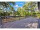 A large back deck with wood railings overlooking a fenced yard and wooded area at 1377 Hill Sw Dr, Conyers, GA 30094