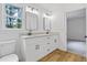 Bathroom featuring double vanity with granite counters, modern fixtures, wood look floors and updated lighting at 1377 Hill Sw Dr, Conyers, GA 30094