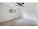 Bright bedroom featuring a ceiling fan, neutral carpet, and a window with a view of the outdoors at 1377 Hill Sw Dr, Conyers, GA 30094