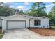 A garage with a white door and concrete driveway is accompanied by a newly landscaped side yard at 1377 Hill Sw Dr, Conyers, GA 30094