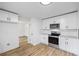 Updated kitchen featuring stainless steel appliances, granite countertops, white cabinets, and wood floors at 1377 Hill Sw Dr, Conyers, GA 30094