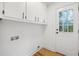 Laundry area featuring updated cabinetry, utility sink, and new flooring and access to rear yard at 1377 Hill Sw Dr, Conyers, GA 30094