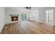 Bright living room featuring a fireplace, wood floors, ceiling fan, and adjacent kitchen and access to the outdoors at 1377 Hill Sw Dr, Conyers, GA 30094