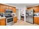 Well-lit kitchen featuring wood cabinets, stainless steel appliances, and a tile floor at 1574 Glenfield Dr, Lawrenceville, GA 30043