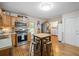 A kitchen features stainless steel appliances, a gas range, wood cabinets, and a light wood kitchen island with metal stools at 2095 Gherry Dr, Austell, GA 30106