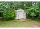 Outdoor storage shed nestled among the trees with a simple wood ramp at 2095 Gherry Dr, Austell, GA 30106