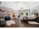 Spacious bedroom featuring hardwood floors, a cozy seating area, and a modern ceiling fan with natural light at 330 Longvue Ct, Johns Creek, GA 30097