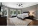 Bedroom with three bright windows, hardwood floors, and ceiling fan at 330 Longvue Ct, Johns Creek, GA 30097