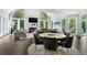 A cozy living room with tall arched windows, a fireplace, and round dining table surrounded by plush upholstered chairs at 330 Longvue Ct, Johns Creek, GA 30097