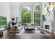 Bright living room boasting a fireplace, high ceilings, tall windows with natural light, and comfortable sofas at 330 Longvue Ct, Johns Creek, GA 30097