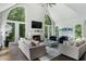 Bright living room with a fireplace, tall arched windows providing stunning views, and stylish comfortable furniture at 330 Longvue Ct, Johns Creek, GA 30097