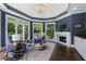 Cozy sitting area featuring hardwood floors, a fireplace, and lots of natural light from the surrounding windows at 330 Longvue Ct, Johns Creek, GA 30097