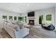 Bright living room with hardwood floors, a fireplace, large windows, and comfortable seating at 330 Longvue Ct, Johns Creek, GA 30097