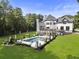 Stunning backyard with a spacious pool area, lounge chairs, well-manicured lawn, and a beautiful white brick home at 330 Longvue Ct, Johns Creek, GA 30097
