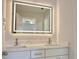 Bright bathroom featuring double sinks, a quartz countertop, and an illuminated mirror at 445 Sweet Ivy Ln, Lawrenceville, GA 30043