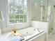 Bright bathroom with shower, tub and large windows at 445 Sweet Ivy Ln, Lawrenceville, GA 30043