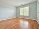 A simple bedroom with hardwood floors and a large window, providing a bright and airy space at 445 Sweet Ivy Ln, Lawrenceville, GA 30043