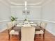 Formal dining room with modern lighting and seating for eight guests at 445 Sweet Ivy Ln, Lawrenceville, GA 30043