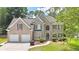 Charming brick two-story home with manicured lawn, two-car garage, and mature landscaping at 445 Sweet Ivy Ln, Lawrenceville, GA 30043