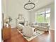 Bright living room features a fireplace, hardwood floors, and a large window at 445 Sweet Ivy Ln, Lawrenceville, GA 30043