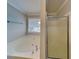 Bathroom featuring a large soaking tub and separate glass-enclosed shower at 115 Hugh Dr, Covington, GA 30016