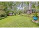 A large backyard with grass and trees with a cabin and a chicken coop at 1526 Oakleaf Dr, Auburn, GA 30011