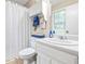 Bathroom features a shower with a curtain, a white vanity with storage, and a window for natural light at 1526 Oakleaf Dr, Auburn, GA 30011