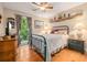 Charming bedroom with hardwood floors, a metal-frame bed, and a window offering views of lush greenery at 1526 Oakleaf Dr, Auburn, GA 30011