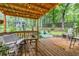 Outdoor deck with wooden furniture and string lights, surrounded by lush greenery at 1526 Oakleaf Dr, Auburn, GA 30011