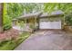 Charming home featuring a welcoming front porch, a two-car garage, and colorful landscaping at 1526 Oakleaf Dr, Auburn, GA 30011