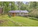 Exterior view showcasing a charming home with a wooden deck and a sprawling green lawn at 1526 Oakleaf Dr, Auburn, GA 30011