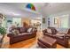 Living room featuring hardwood floors and comfortable leather seating, with a glimpse into the kitchen at 1526 Oakleaf Dr, Auburn, GA 30011