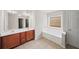 Primary bathroom with double sinks, a soaking tub, and tile flooring at 162 Ledgewood Mill Way, Lawrenceville, GA 30045