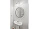 Half bath with stylish pedestal sink, decorative mirror, modern lighting, and a coordinating towel rack at 162 Ledgewood Mill Way, Lawrenceville, GA 30045