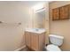 Bathroom featuring a beige vanity, mirror and lights, with a wicker wall hanging, and toilet at 2578 Morgan Lake Ne Dr, Marietta, GA 30066